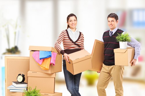 Trained movers carrying furniture carefully during a Brent removal
